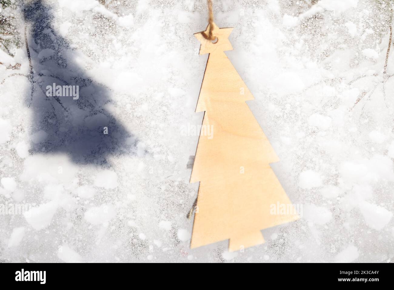 Defocus Christmas toy. Wooden model winter pine tree with yellow star on white snowy background. Christmas tree hanging. Winter holiday concept. Out o Stock Photo