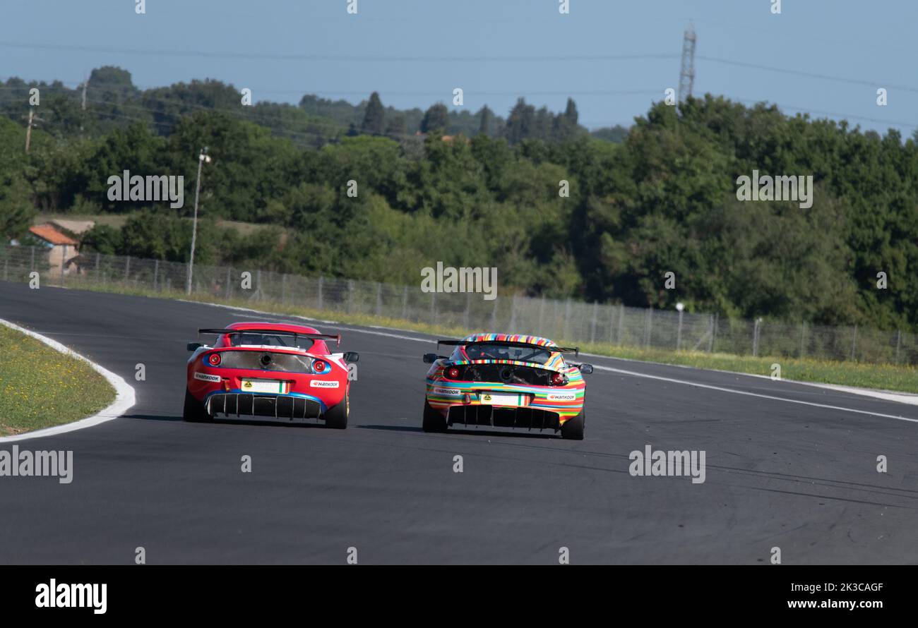 Lotus Exige race cars challenge overtaking on racetrack rear view