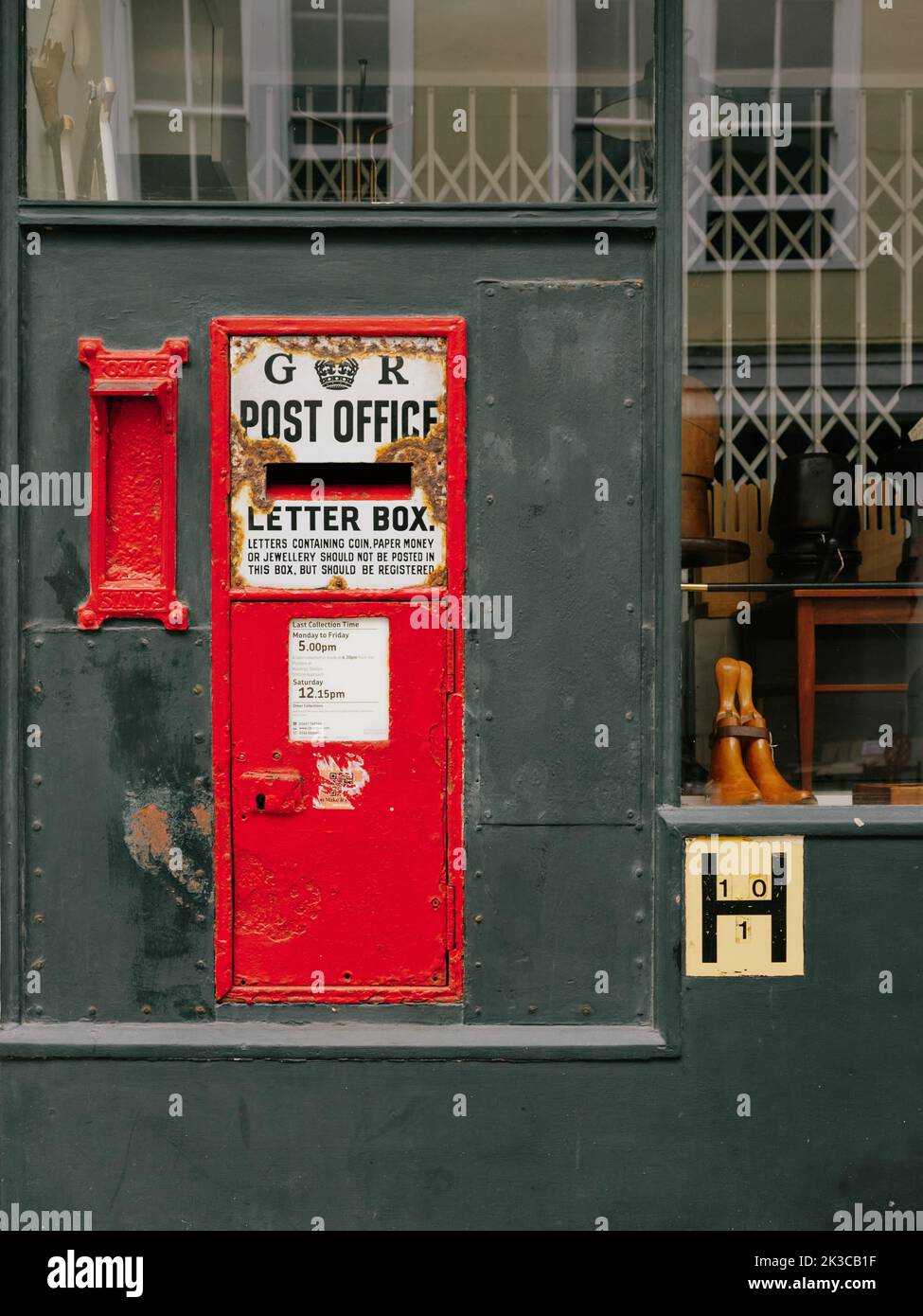 An old red wall post box and shop window in Hastings Old Town,Hastings, East Sussex, England UK Stock Photo
