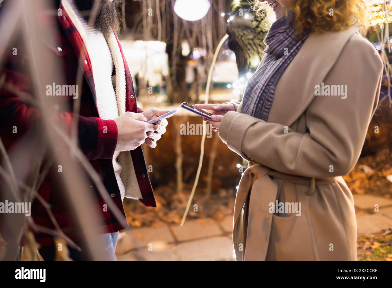 Detail of a couple holding smartphones close to each other and connecting Stock Photo
