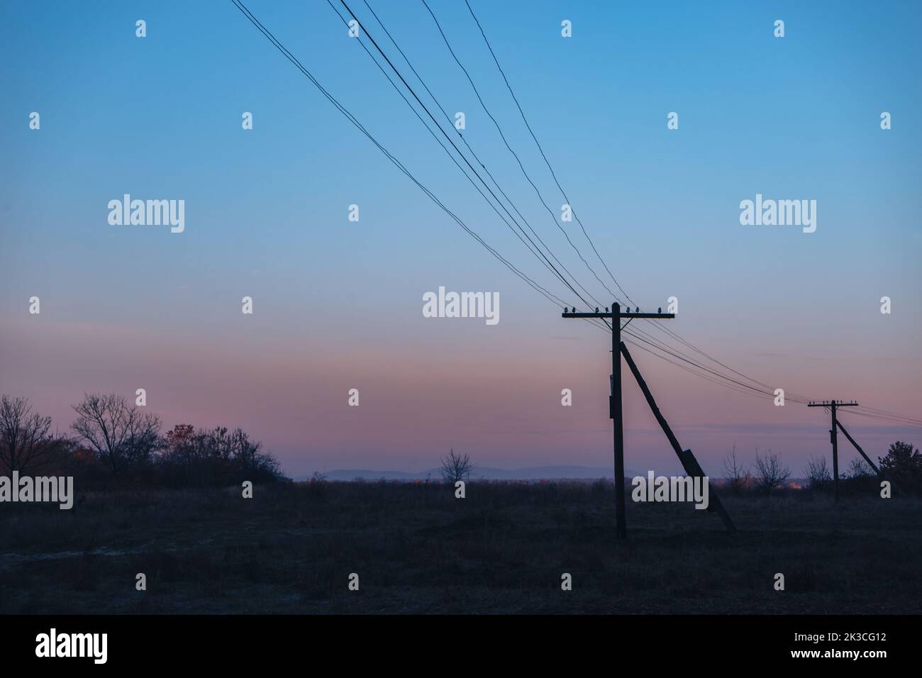 Colorful sunrise over the with trees and electric pole Stock Photo - Alamy