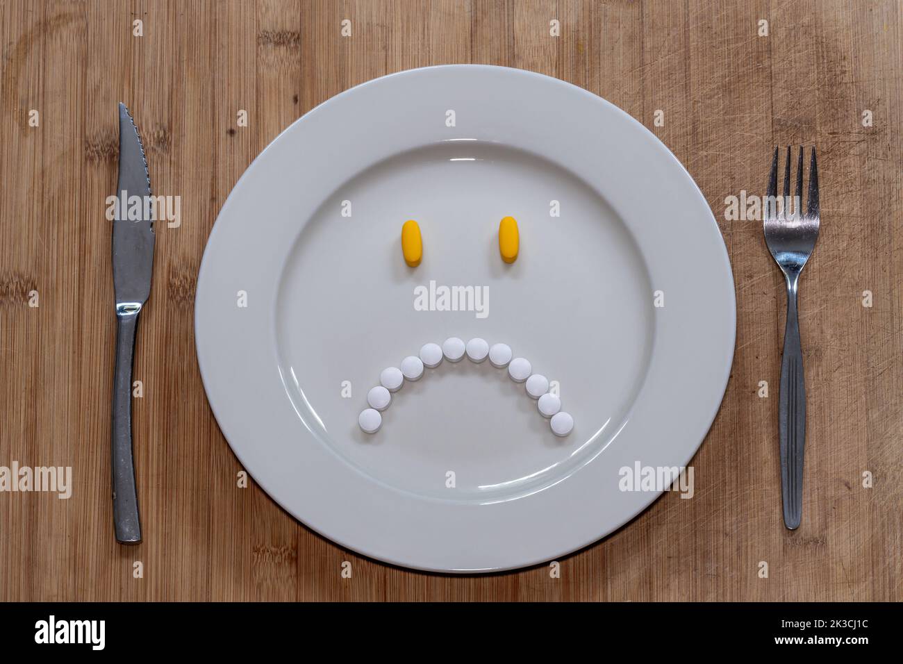 Pills on the plate in the shape of miserable and unhappy face, healthcare, dieting or taking medication concept Stock Photo