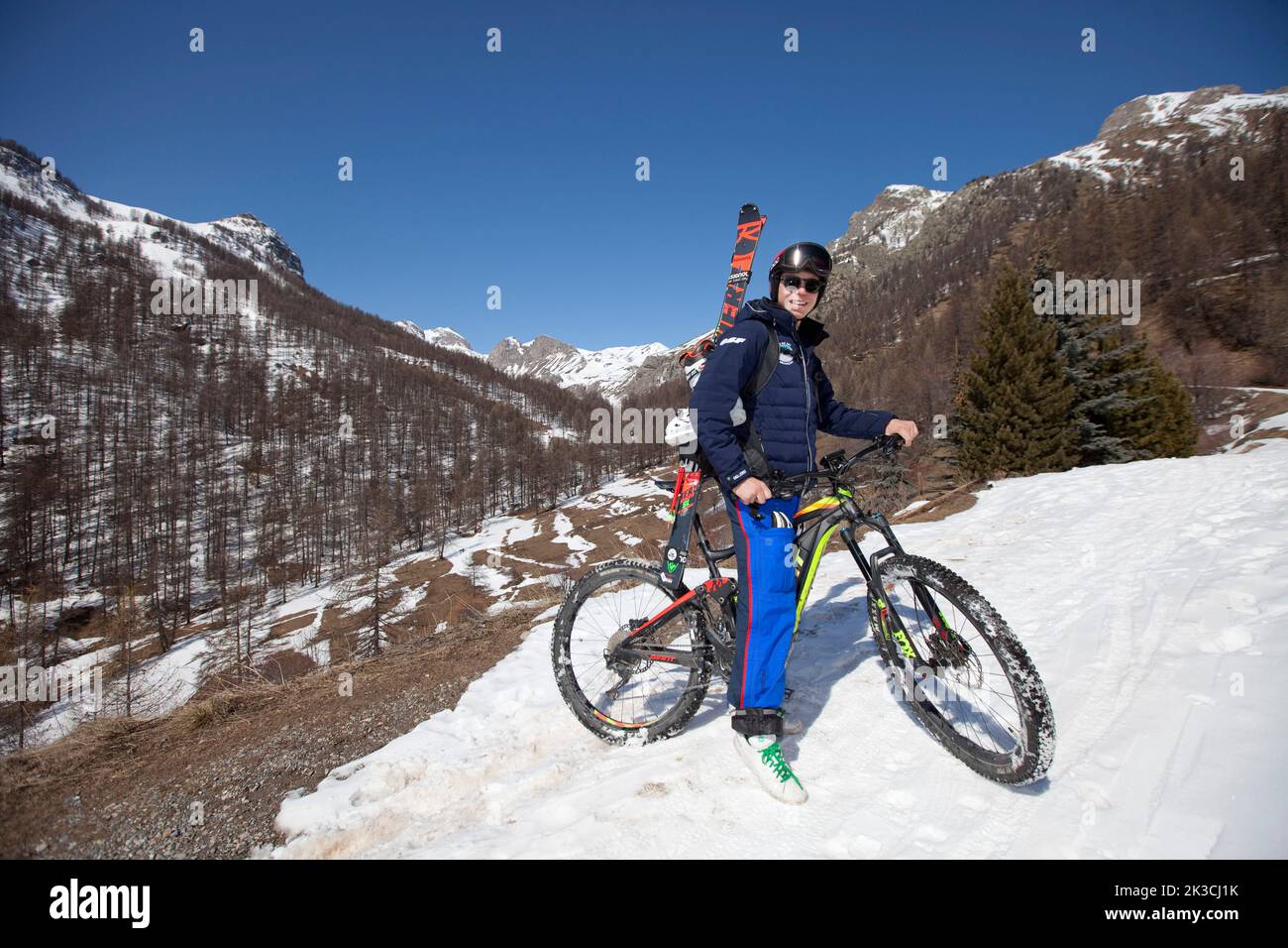 Arthur Bauchet goes skiing in electric mountain bike to raise awareness of renewable energies, France on March 20, 2021. Energy efficiency will be the name of the game in the Alps this winter, with more than a third of resorts renegotiating their supply contracts and anticipating steep increases. According to the France Montagnes organization, 10 million tourists visit the country's ski resorts every winter, most of them in the French Alps, which host the largest concentration of resorts in the country – almost 200. All of them are subject to a public service contract that considers their ski Stock Photo