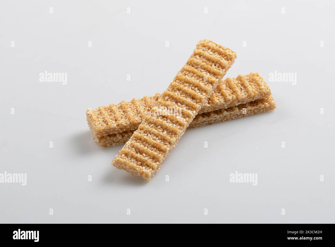 sesame seed candy bars, in a wooden bowl. Sesame brittle or crunch, a confection of sesame seeds and honey pressed into flat bars, a popular snack in Stock Photo