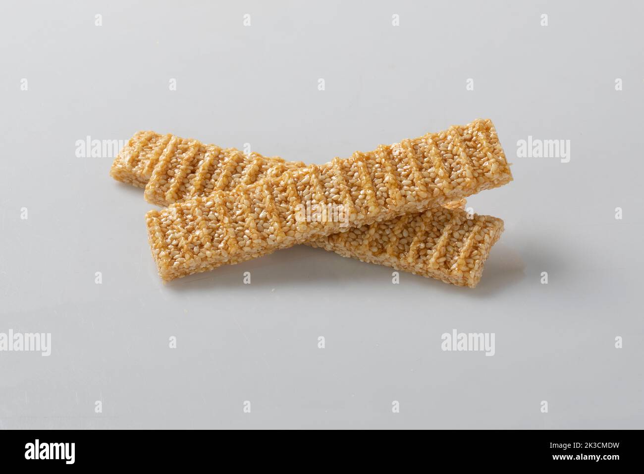 sesame seed candy bars, in a wooden bowl. Sesame brittle or crunch, a confection of sesame seeds and honey pressed into flat bars, a popular snack in Stock Photo