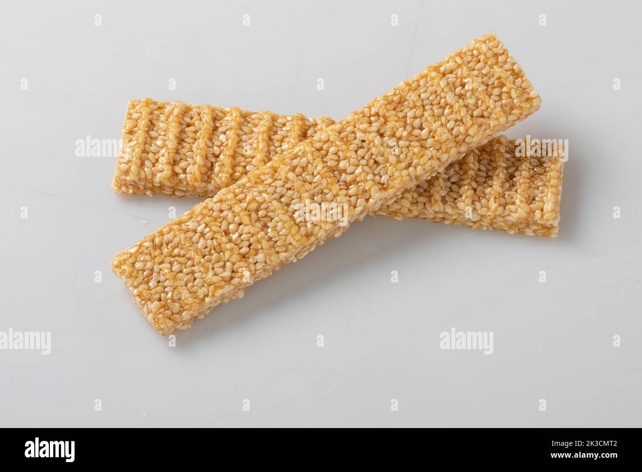 sesame seed candy bars, in a wooden bowl. Sesame brittle or crunch, a confection of sesame seeds and honey pressed into flat bars, a popular snack in Stock Photo