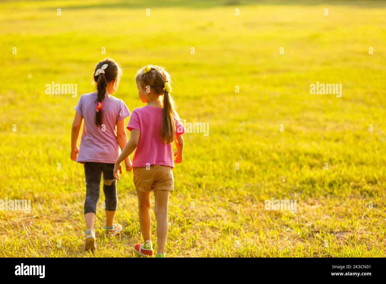 two little girls walking in the field Stock Photo - Alamy
