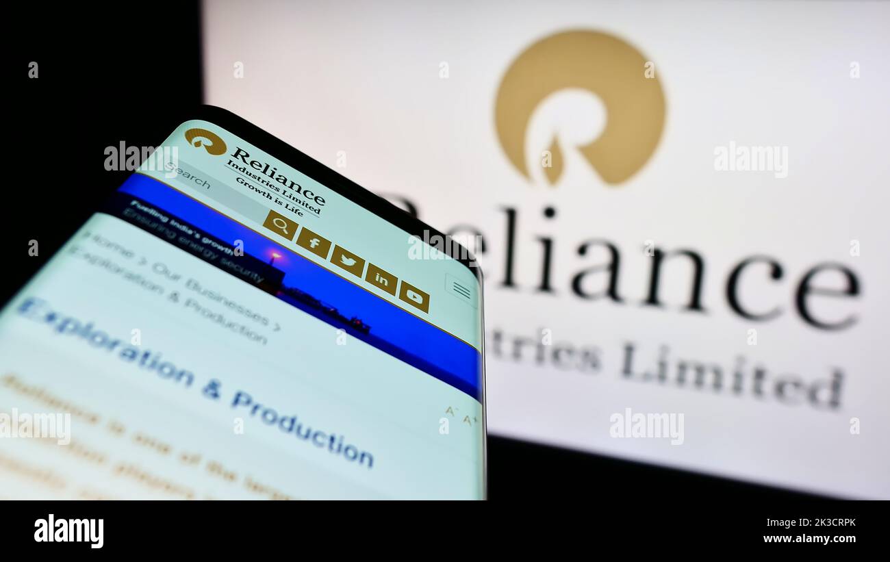 Smartphone with website of Indian company Reliance Industries Limited on screen in front of business logo. Focus on top-left of phone display. Stock Photo