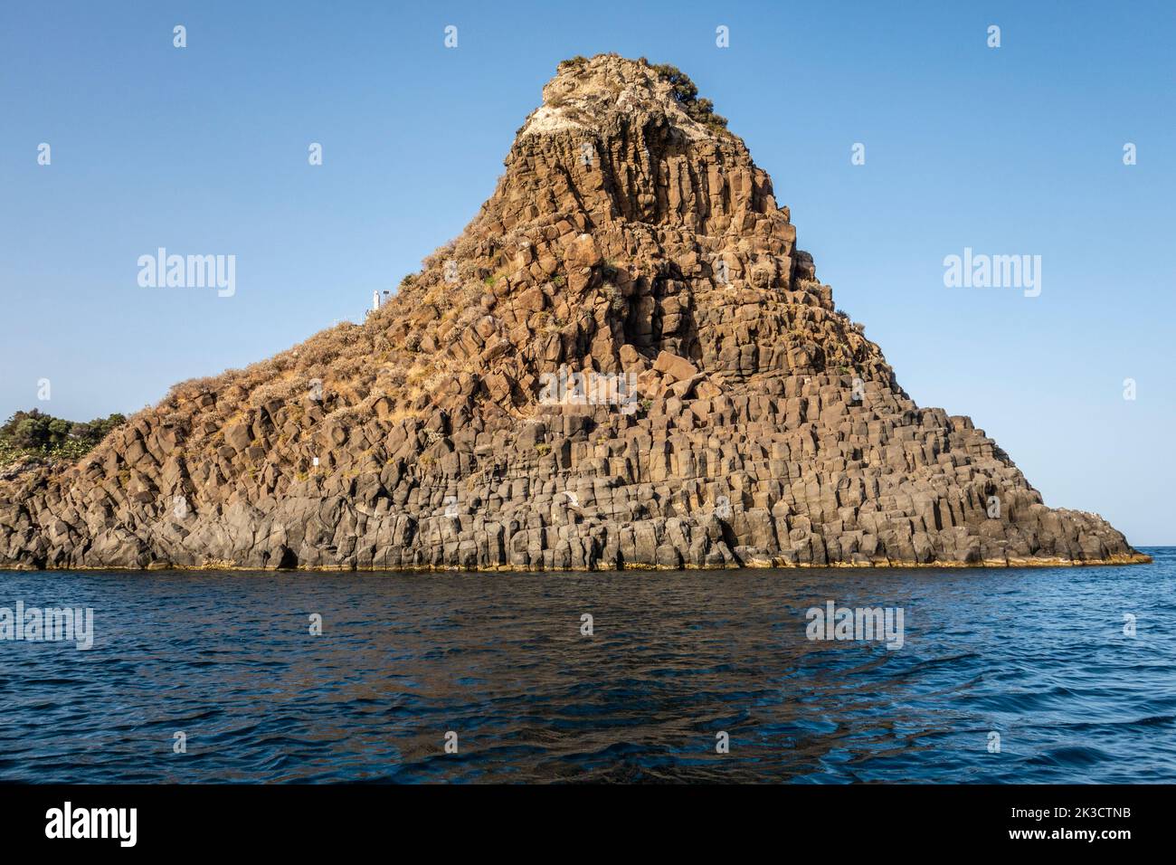 Faraglione Grande, one of the Faraglioni or Isole dei Ciclopi (Cyclopean Islands), a group of volcanic basalt sea stacks off Aci Trezza, Sicily, Italy Stock Photo