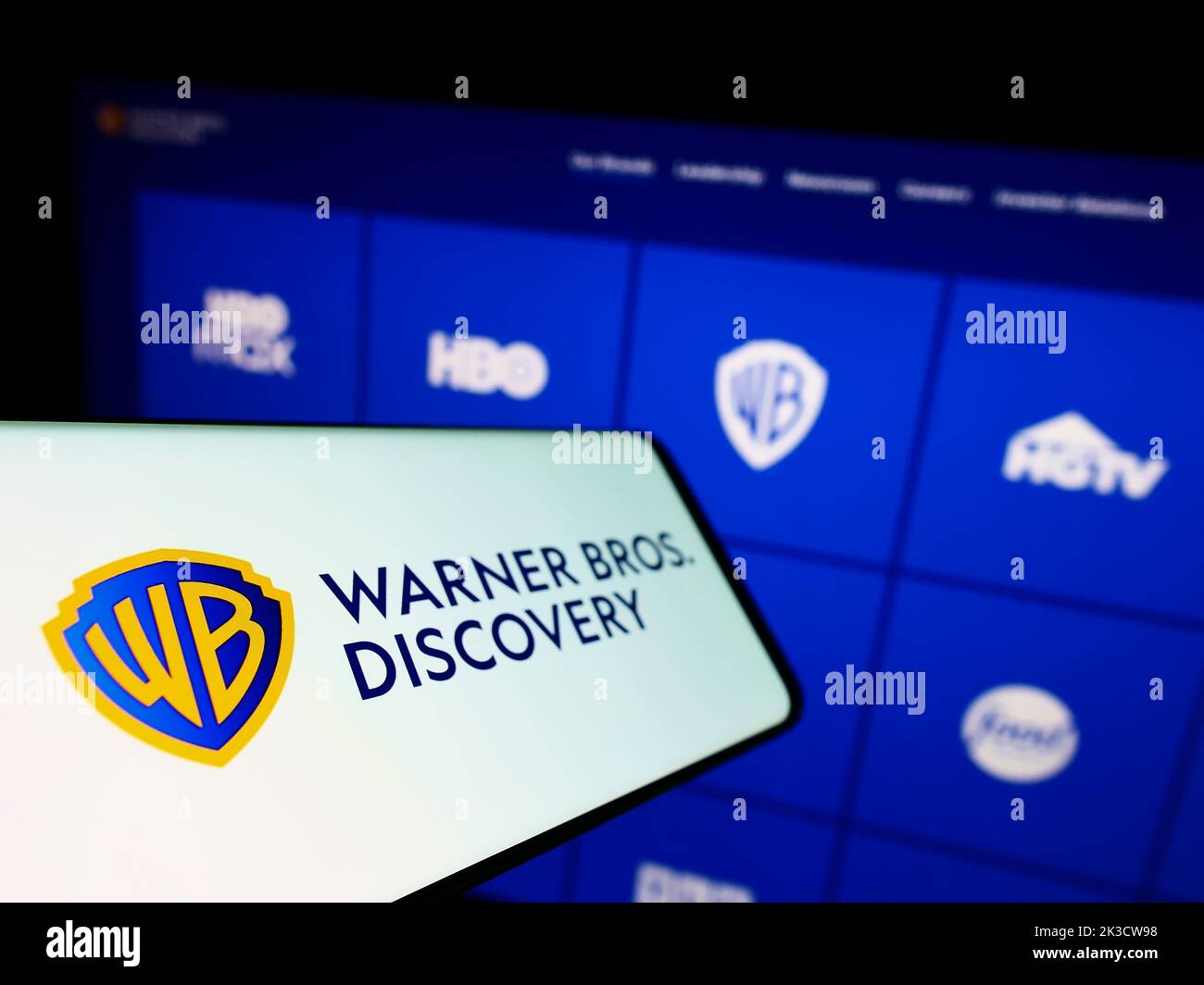 Mobile phone with logo of media company Warner Bros. Discovery Inc. (WBD) on screen in front of business website. Focus on left of phone display. Stock Photo