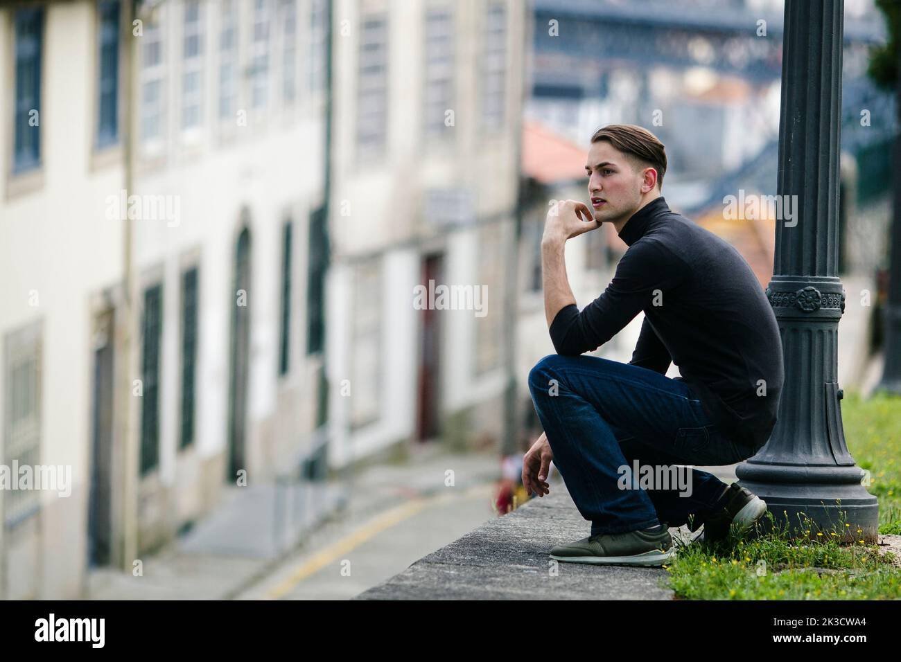 Handsome young man sitting on the street in downtown Stock Photo - Alamy