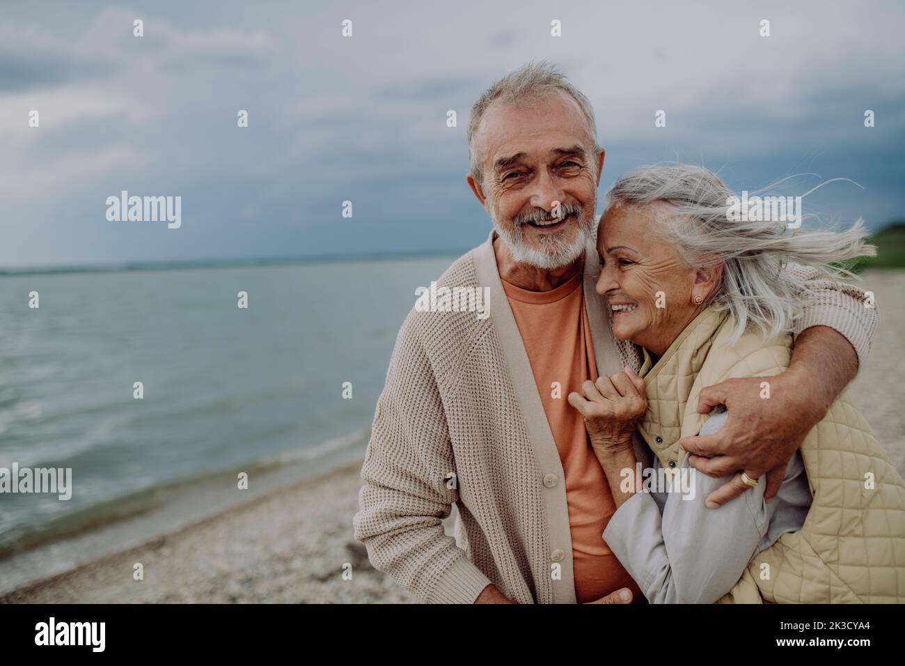 Senior couple relaxing and having romantic moment near the autumn sea. Stock Photo