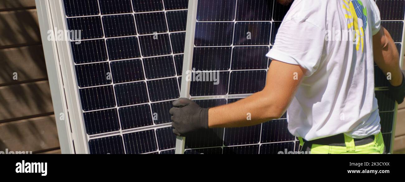 Close-up of man worker carrying solar panel for installing. Stock Photo