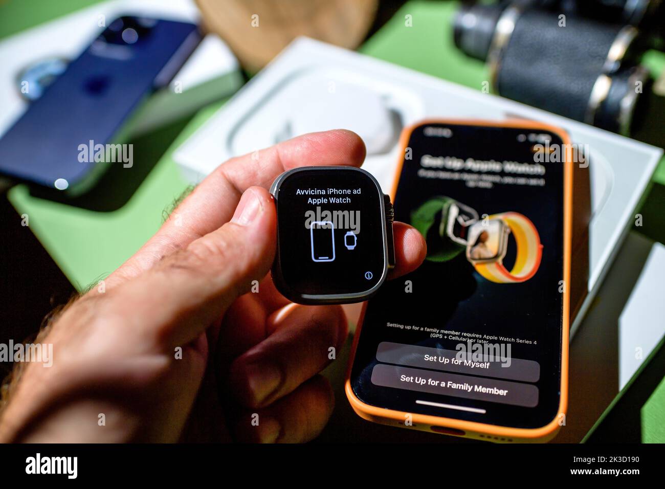 London, United Kingdom - Sep 23, 2022: bring the iPhone closer to the Apple Watch translation from italian avvicina iPhone ad Apple watch during setup of ew titanium Apple Watch Ultra designed for extreme activities like endurance sports, elite athletes, trailblazing, adventure Stock Photo