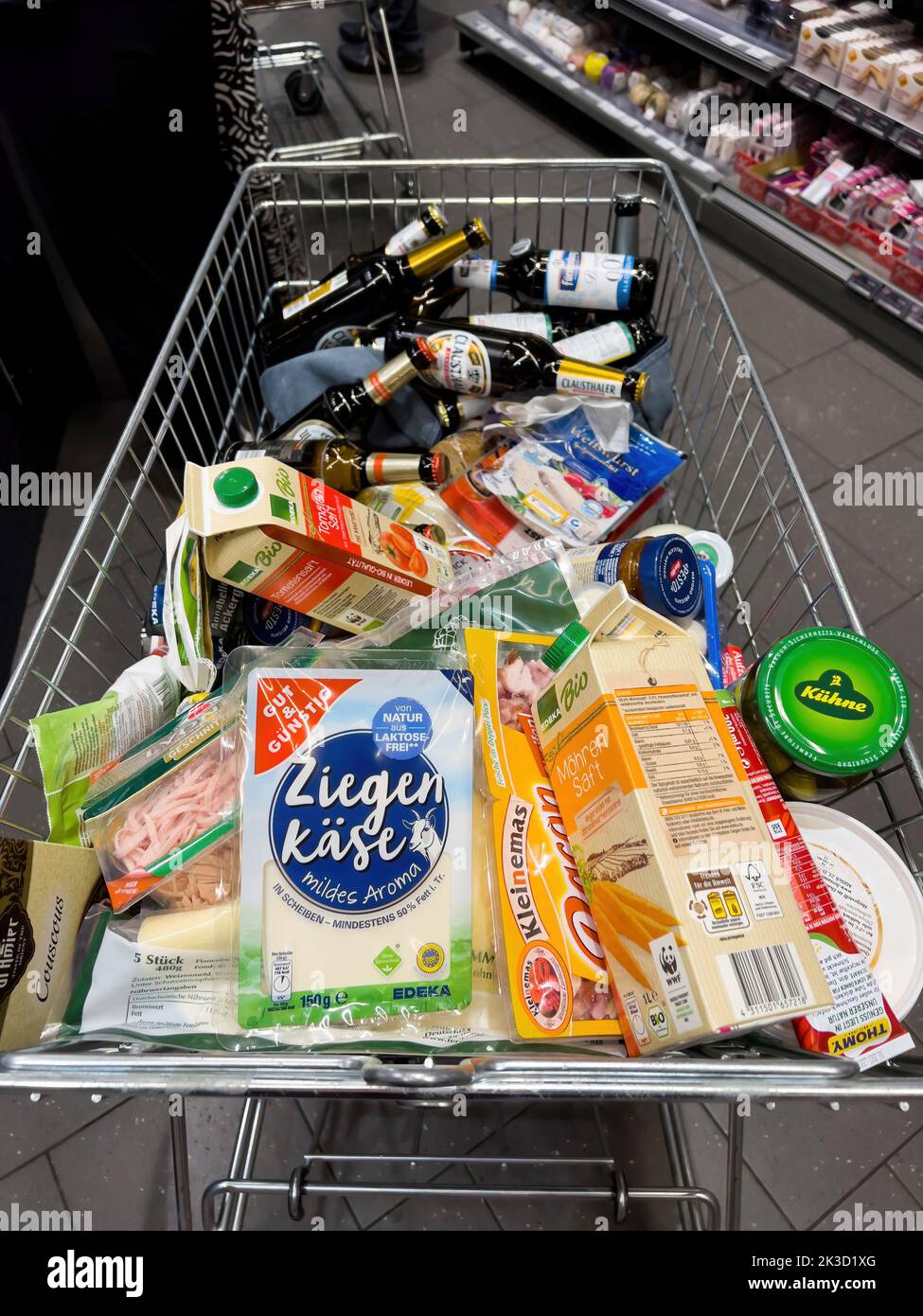 Frankfurt, Germany - Sep 17, 2022: full shopping cart of groceries at a convenience store in German Edeka gut und gunstig - high rised prices at all groceries food products in Germany due to COVID and War in Ukraine Stock Photo