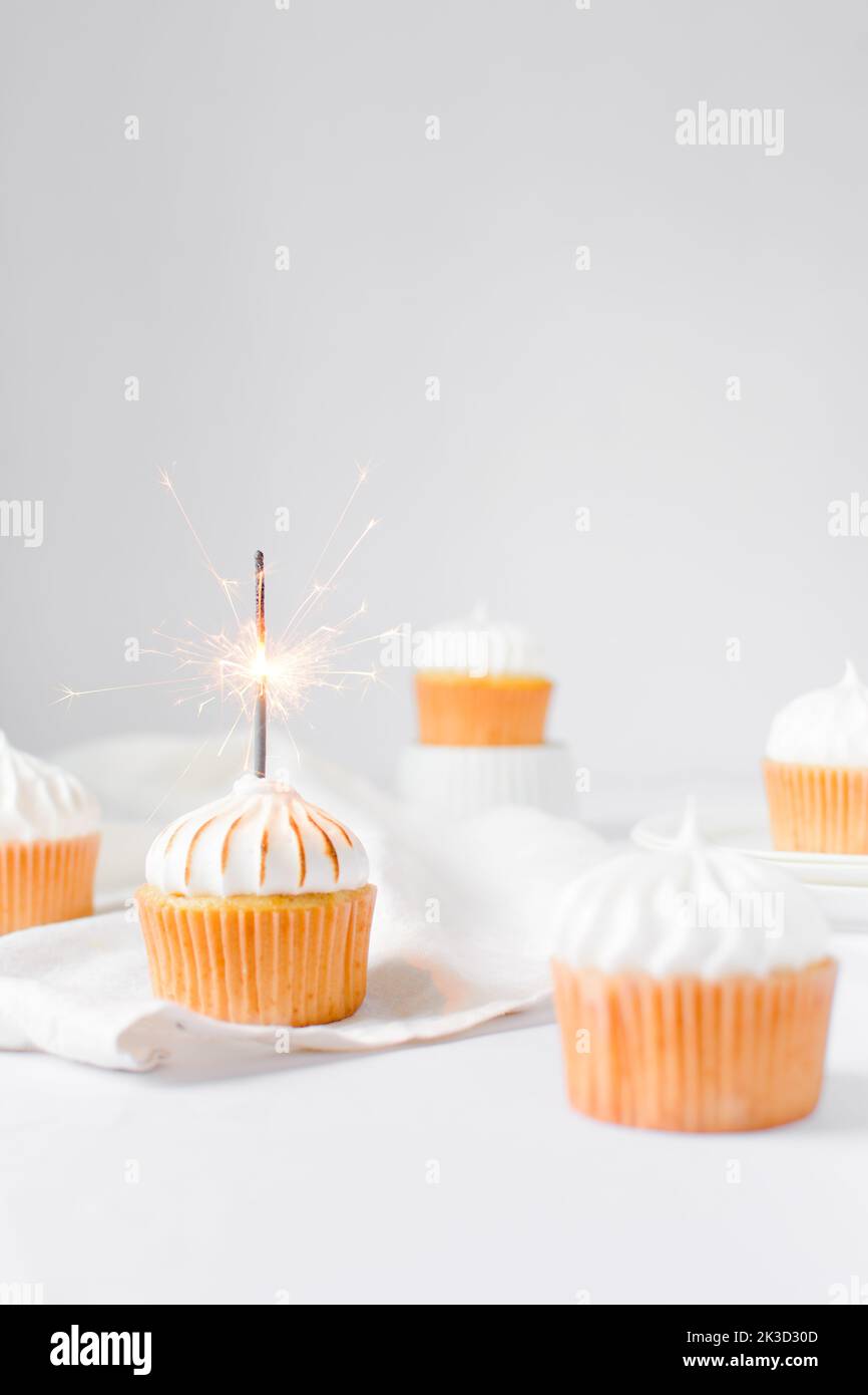 Cupcake with white frosting and a sparkler, birthday cupcake with a sparkler Stock Photo