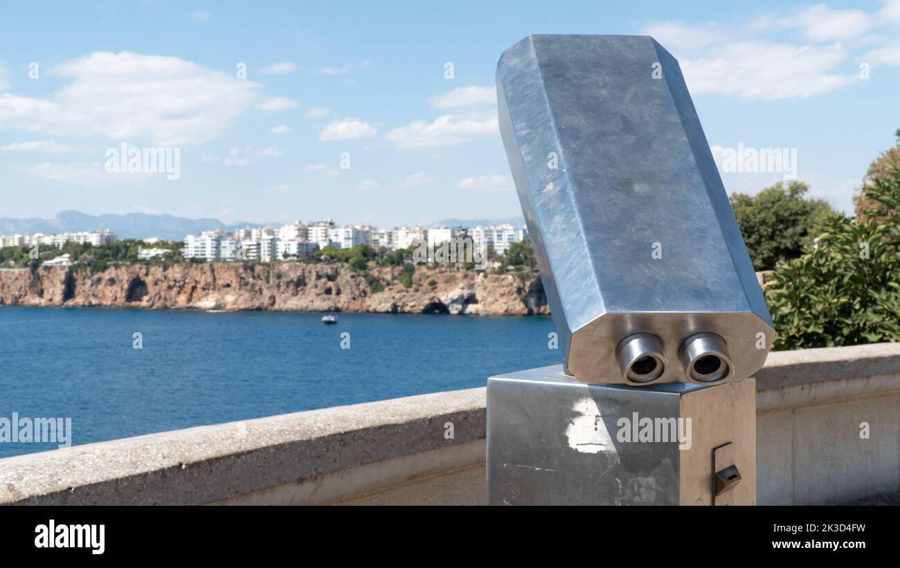 Stationary viewing binoculars in the park with a view of the city and the rocks Stock Photo