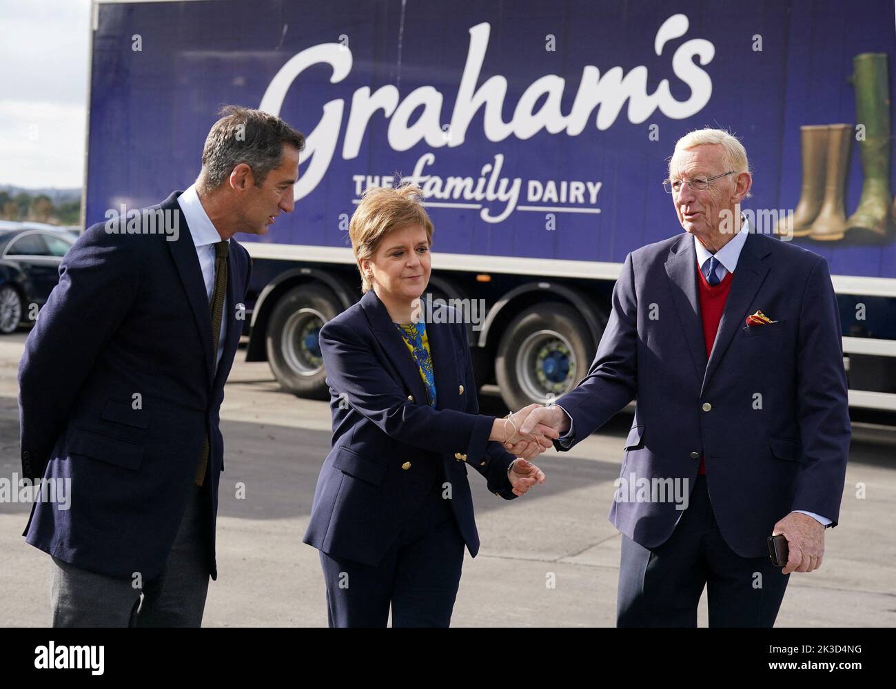Scottish First Minister Nicola Sturgeon shakes hands with Chairman Dr Robert Graham while Managing Director Robert Graham looks on during a visit to Graham's The Family Dairy to mark the start of Scotland's Climate Week, as she announces funding to help companies decarbonise, in Bridge of Allan, Stirling, Scotland, Britain September 26, 2022. Andrew Milligan/Pool via REUTERS Stock Photo