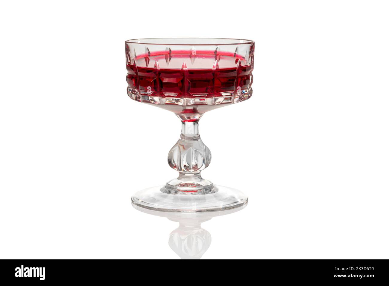 Vintage glass with Alchermes, Cassis red blackcurrant liqueur in antique glass isolated on white, clipping path Stock Photo