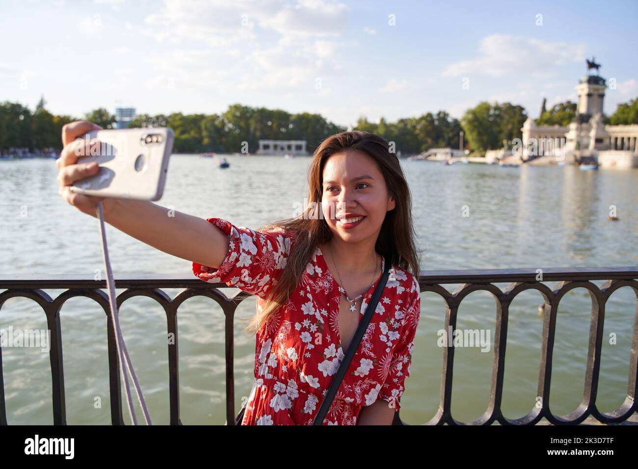 attractive latina taking a selfie in the retiro park in madrid. Young tourist visiting madrid Stock Photo