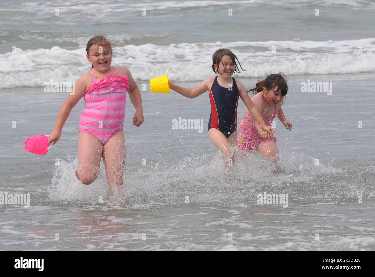 Left to right, Lily Wooster, 9, Phoebe Grimshaw,8, and her sister Courtney, 6, enjoy the hottest day of the year on the beach at West Wittering, West, Sussex. Pic Mike Walker,2015 Mike Walker Pictuires Stock Photo