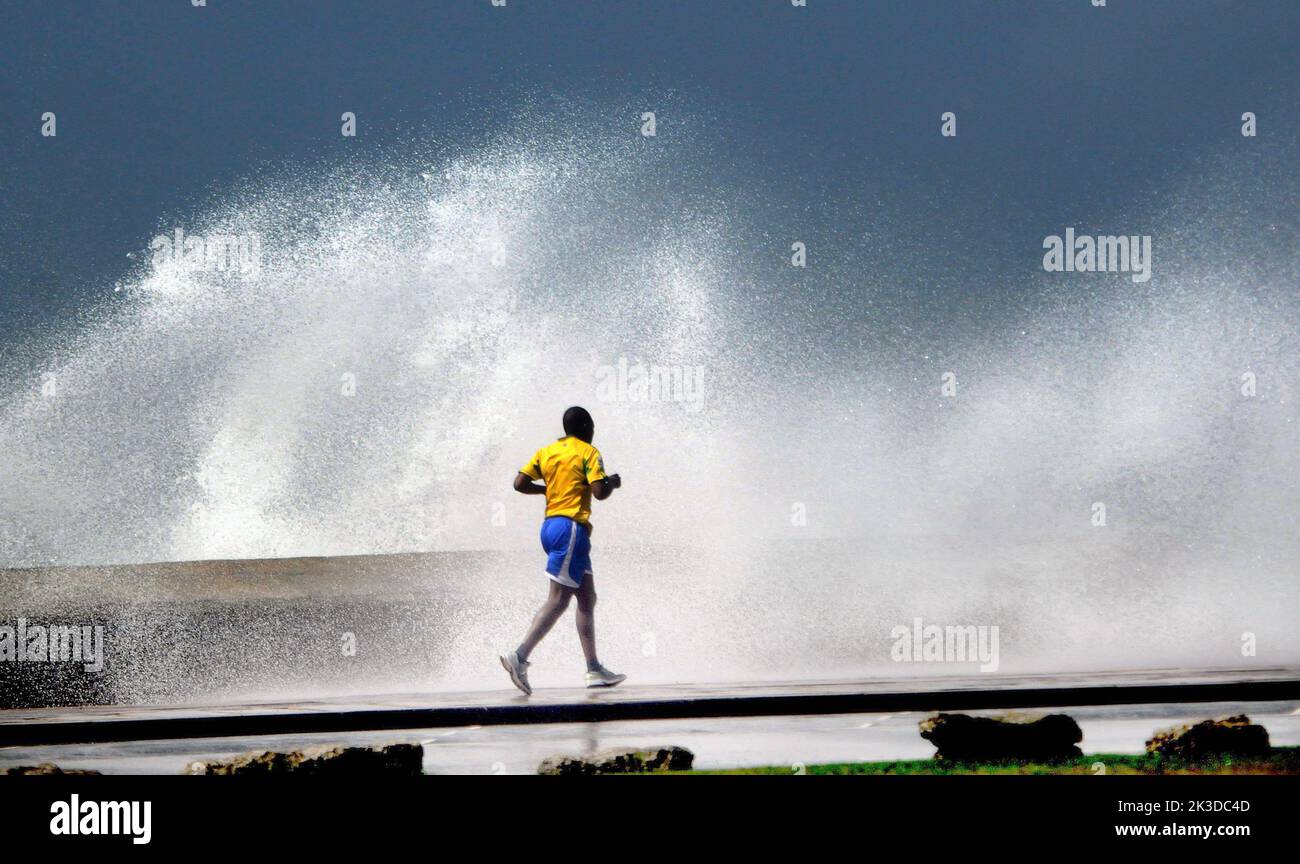 A jogger braves the waves lashing the seafront at Southsea , Hants as May gales hit the South Coast.. Pic Mike Walker,2015 Mike Walker Pictures Stock Photo