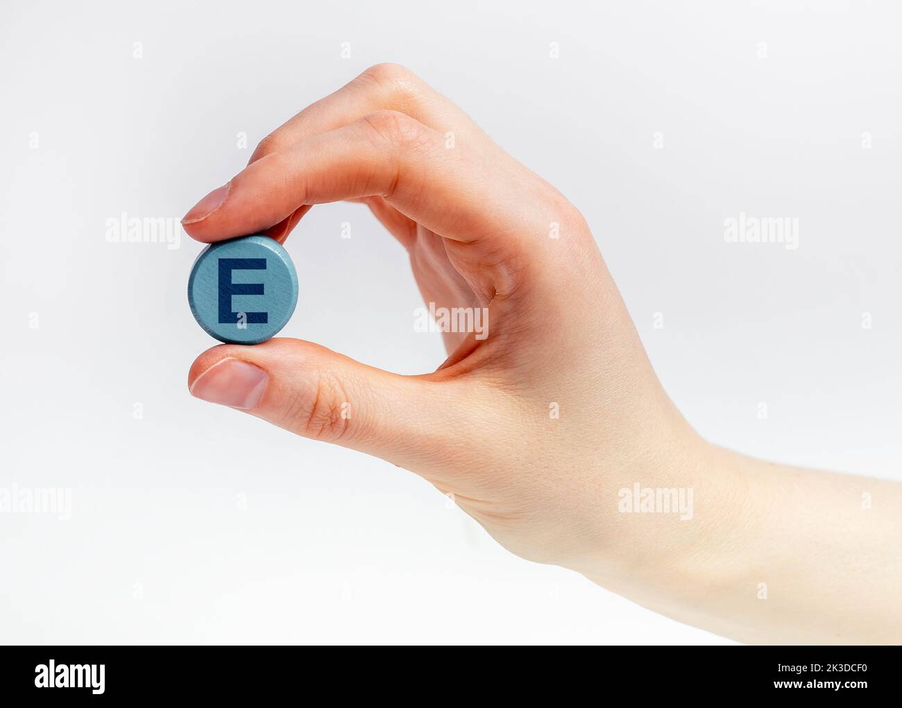 E vitamin round pill between fingers closeup. High quality photo Stock Photo