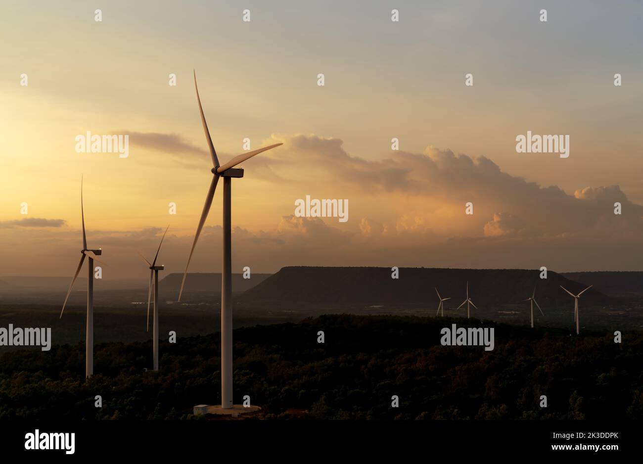 Wind energy. Wind power. Sustainable, renewable energy. Wind turbines generate electricity. Windmill farm on mountain with sunset sky. Green energy Stock Photo