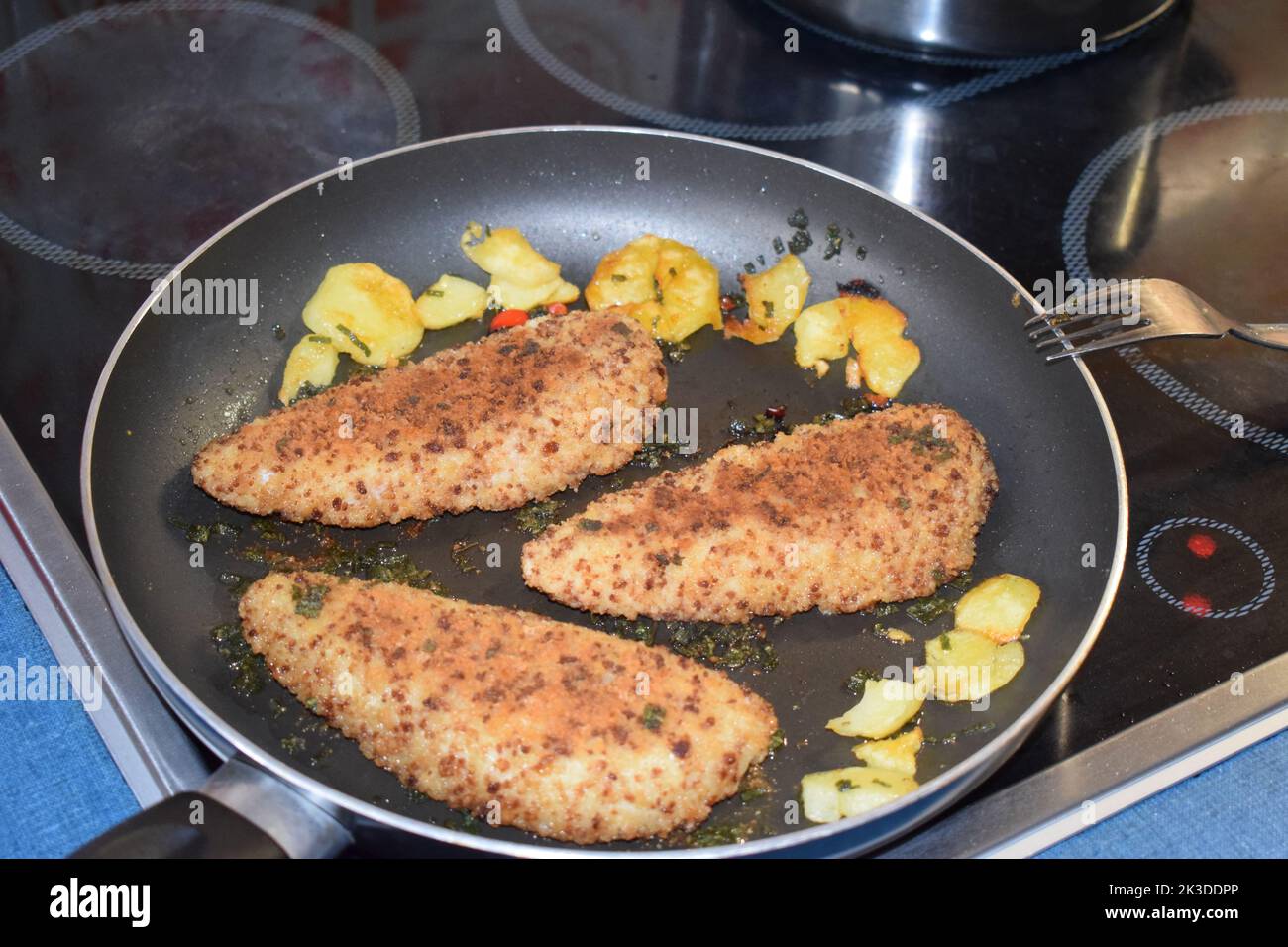 pretzel breading on fish in the pan Stock Photo