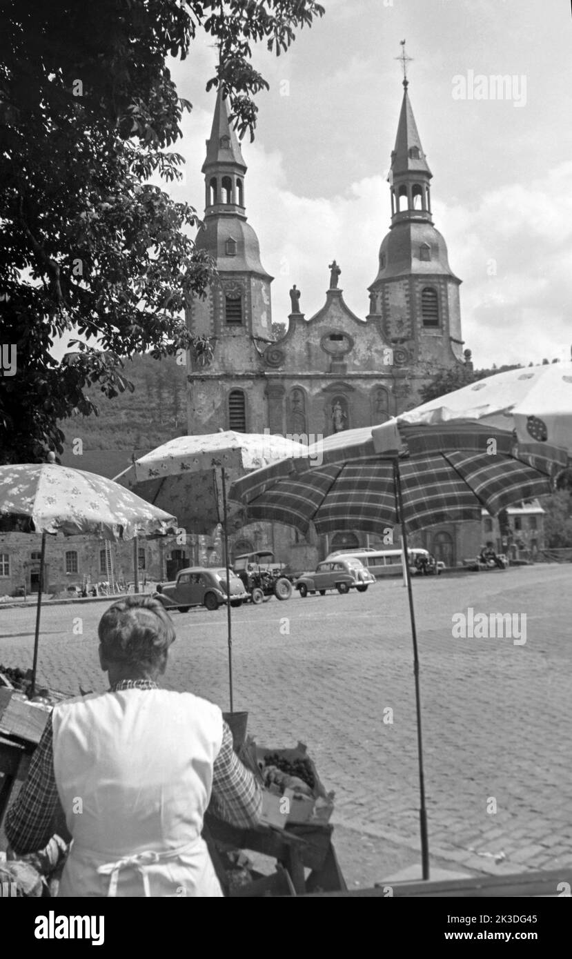 Verkaufsstand auf dem Hahnplatz mit der Basilika Sankt Salvator im Hintergrund, circa 1952. Sales stand at Hahnplatz with Prüm Basilica in the background, around 1952. Stock Photo