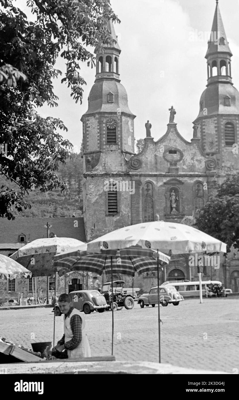 Verkaufsstand auf dem Hahnplatz mit der Basilika Sankt Salvator im Hintergrund, circa 1952. Sales stand at Hahnplatz with Prüm Basilica in the background, around 1952. Stock Photo
