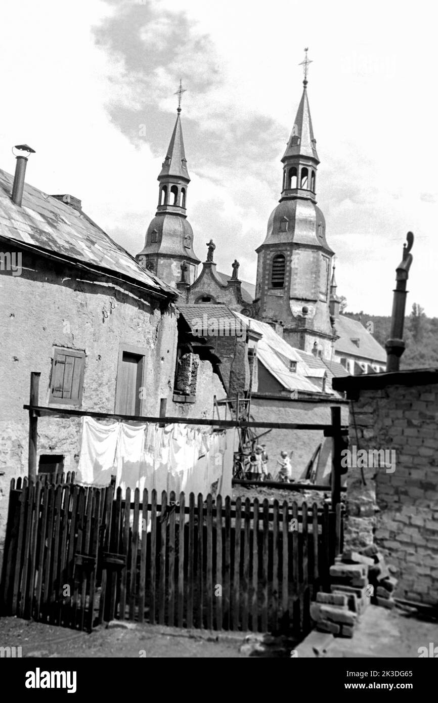 Hinterhof mit Blick auf die Basilika Sankt Salvator, Prüm in der Eifel, circa 1952. Backyard with a view of Prüm Bailica in Prüm, Eifel Region, around 1952. Stock Photo