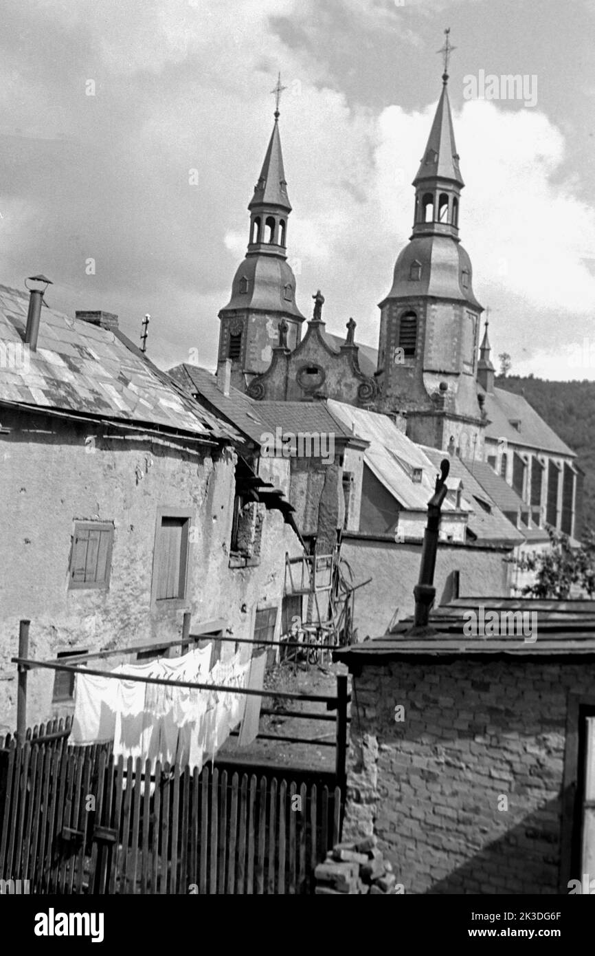 Hinterhof mit Blick auf die Basilika Sankt Salvator, Prüm in der Eifel, circa 1952. Backyard with a view of Prüm Bailica in Prüm, Eifel Region, around 1952. Stock Photo