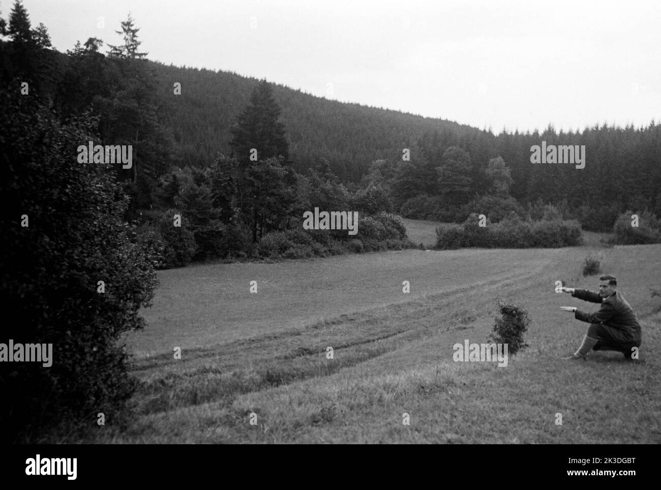 Wanderung durch die Eifel - Ein Mann deutet in die Eifellandschaft, 1952. Hike through the Eifel - A man signalling into the Eifel region-landscape, 1952. Stock Photo