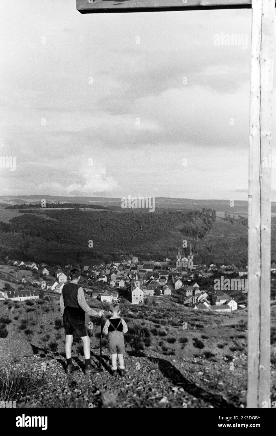 Jungen beim Wandern mit Blick auf Prüm in der Eifel, 1952. Boys hiking with a view of Prüm in the Eifel region, 1952. Stock Photo
