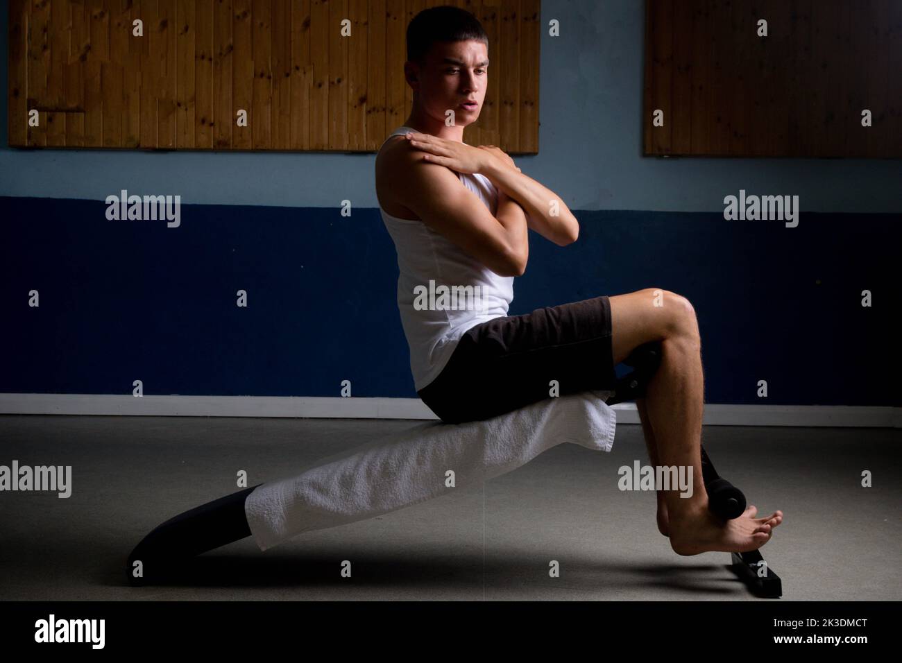 19 year old teenage boy doing situps on an excercise bench in a tank top Stock Photo