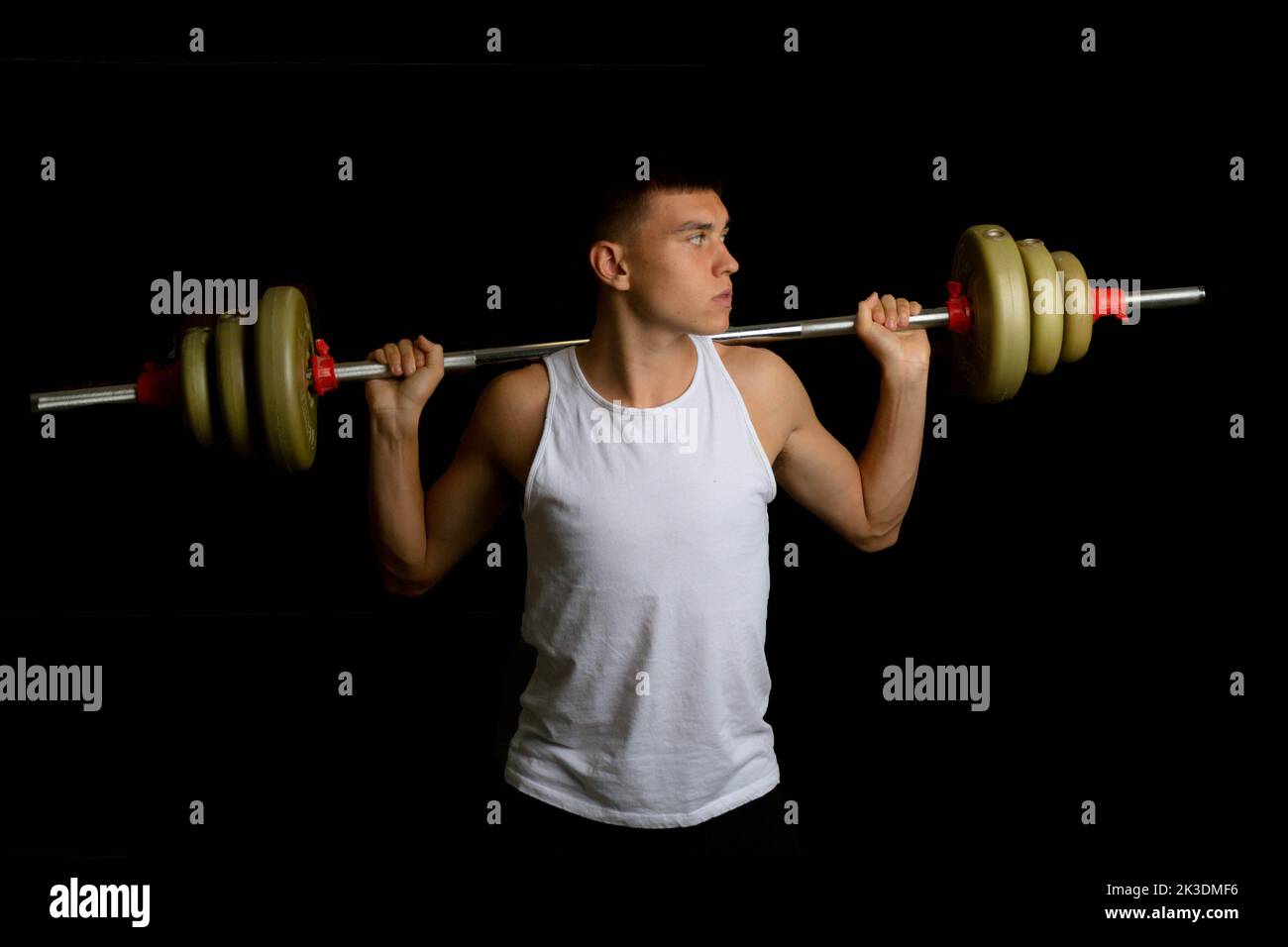 19 year old teenage boy with a barbell across his shoulders Stock Photo