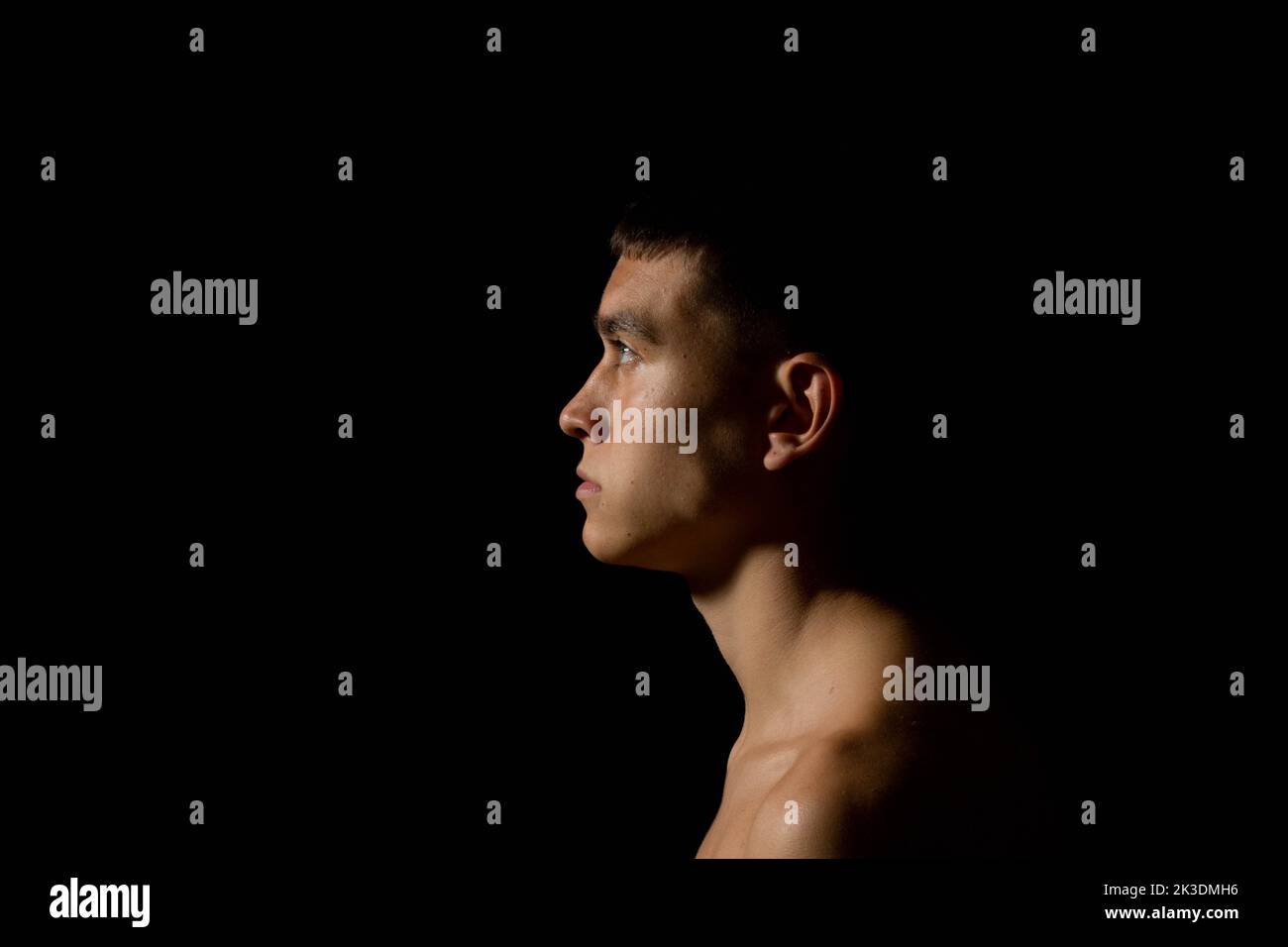 Side view of the head of a 19 year old teenage boy on black background Stock Photo