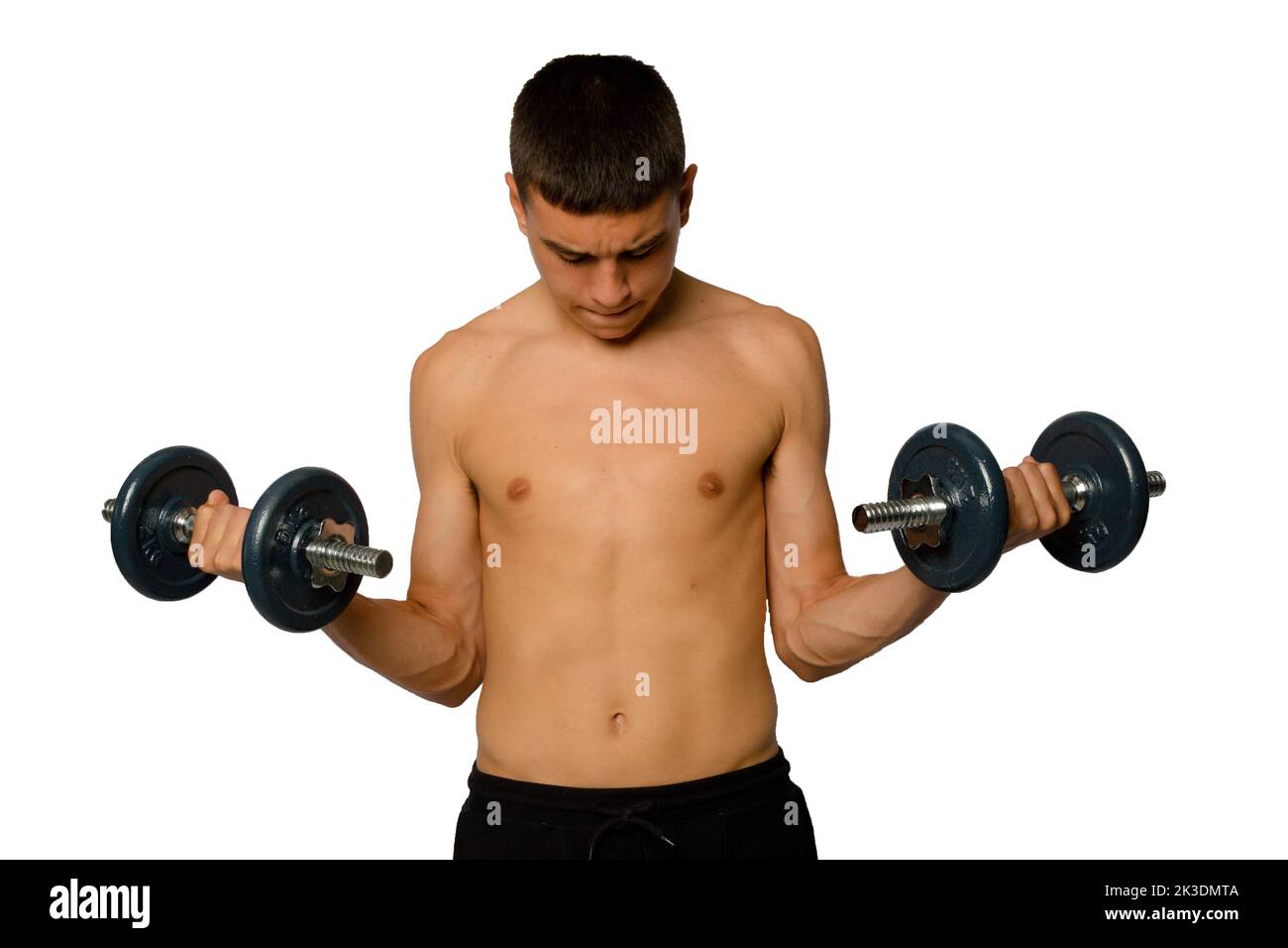 Shirtless 19 year old teenage boy lifting dummbells Stock Photo