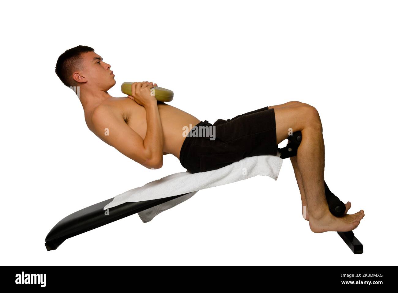 Shirtless 19 year old teenage boy doing situps with extra weight Stock Photo
