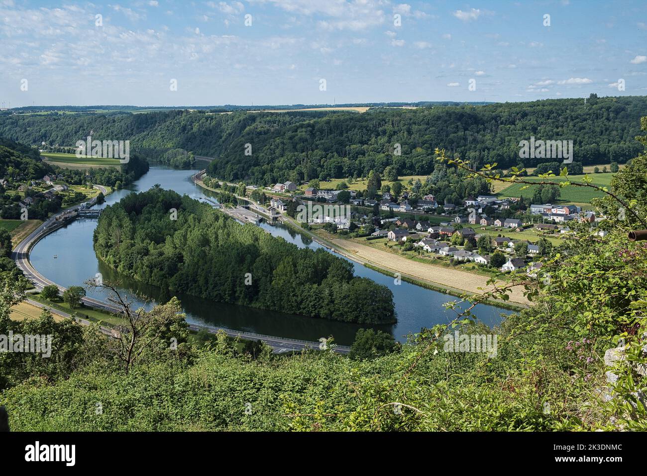 A high-angle shot of Poilvache castle precinct with a lake and forested hills, blue sky background Stock Photo