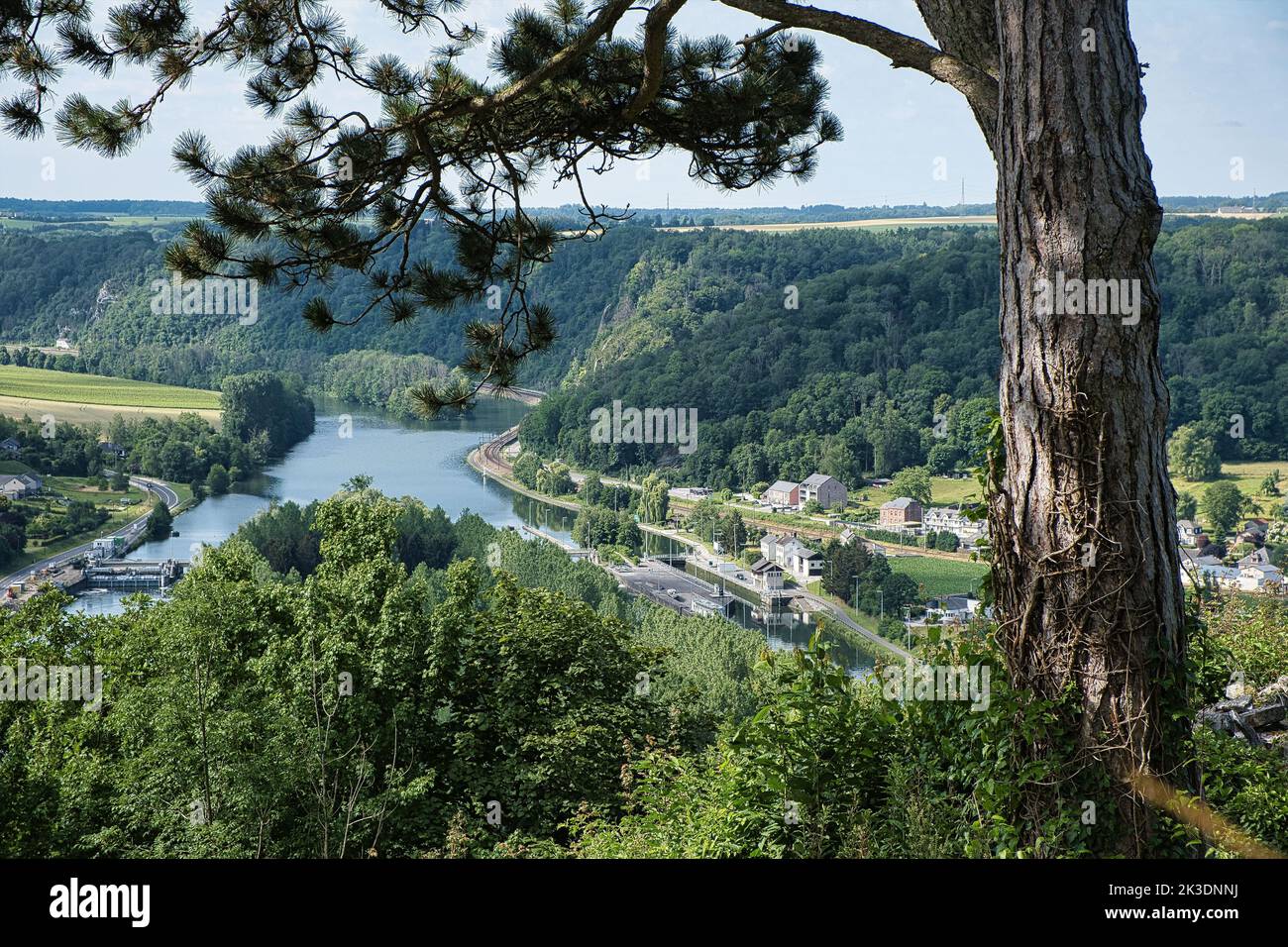 A high-angle shot of Poilvache castle precinct with a lake and forested hills, blue sky background Stock Photo