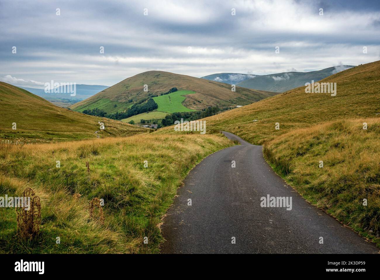 The top of Adamthwaite Bank, a steep dead end road, looking to the farm in the Howgills near Ravenstonedale, Cumbria, England, UK Stock Photo
