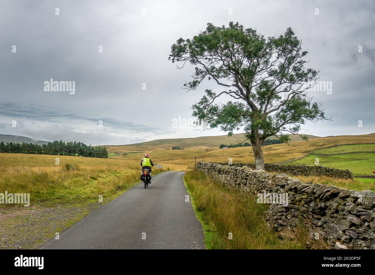 Senior cyclist on an e-bike exploring the lanes around Ravenstonedale in the Howgills Cumbrian hills, England, UK Stock Photo