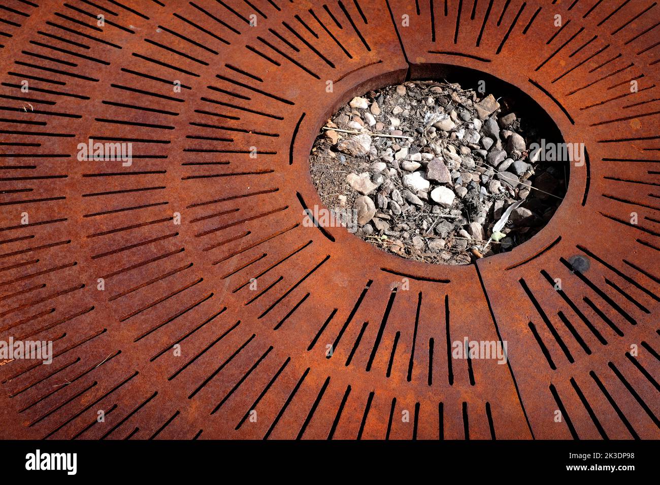 Rusty metal grate texture with rocks and soil in circle shape Stock Photo