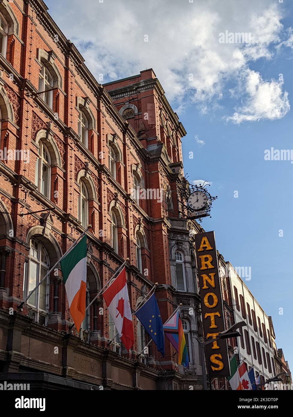 A vertical shot of the irish Arnotts pub with flags in Dublin, Ireland