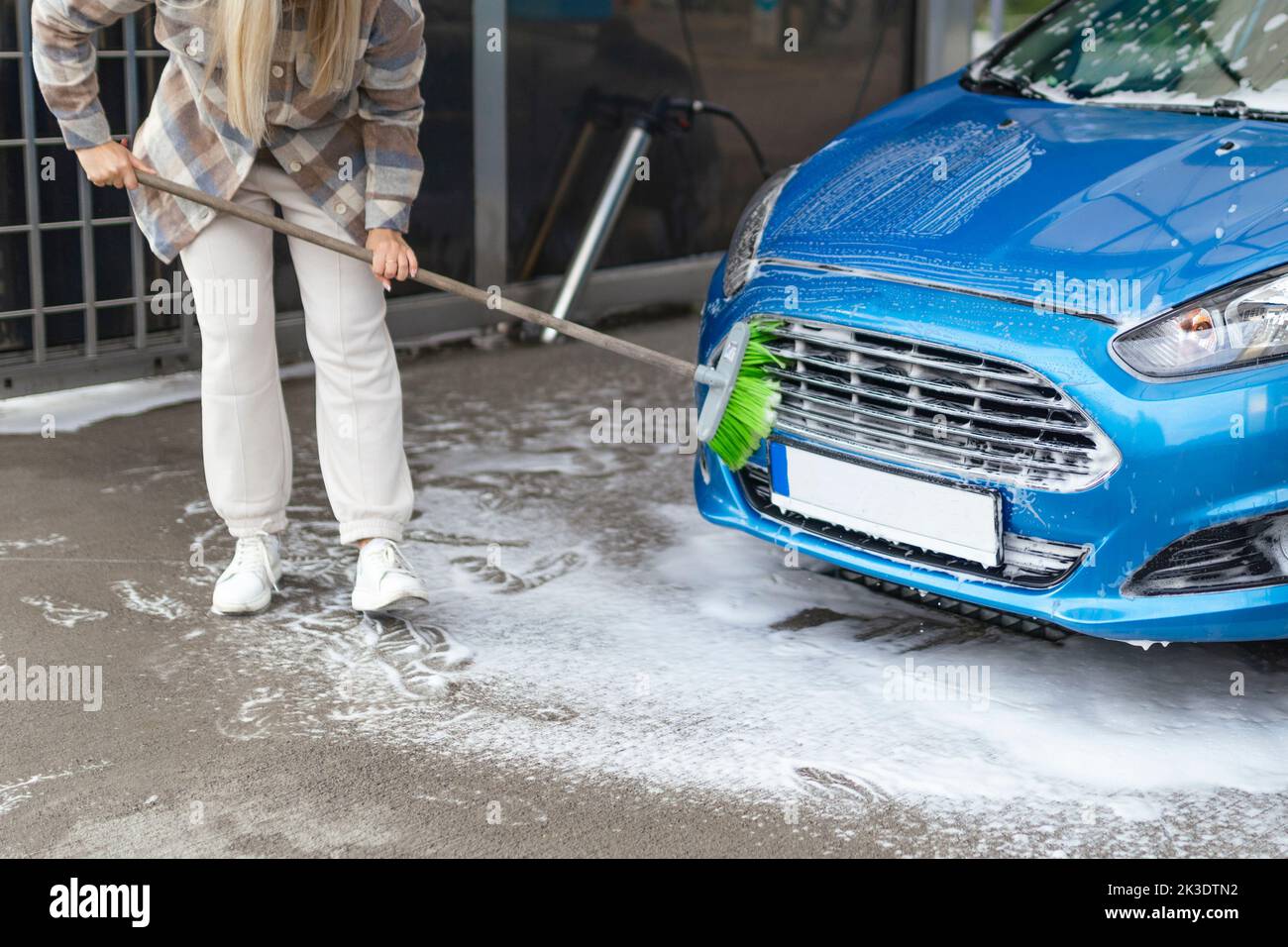 the women herself at the car wash washes the car with a brush Stock Photo Alamy