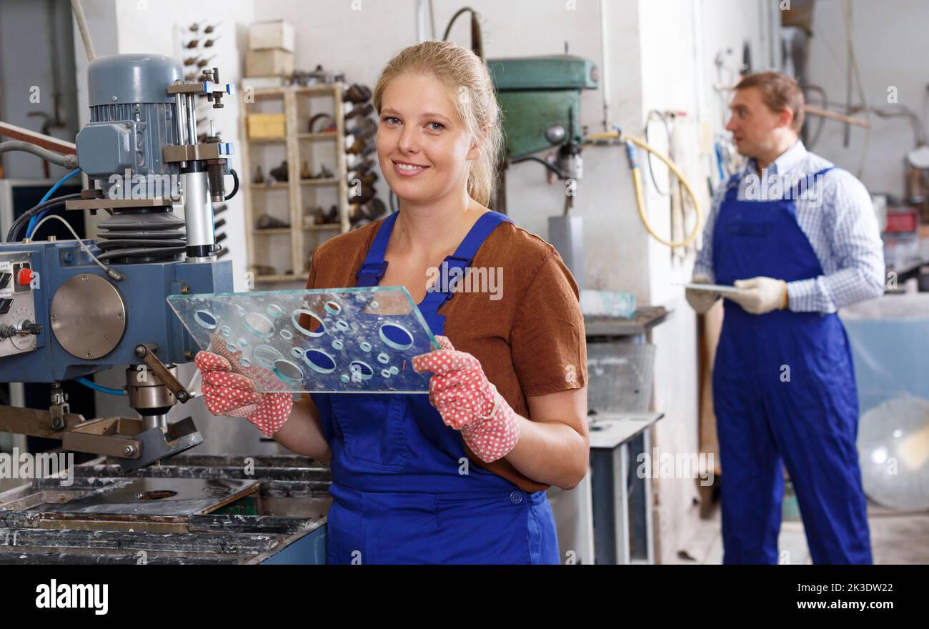 Female glazier working with glass drilling machine Stock Photo