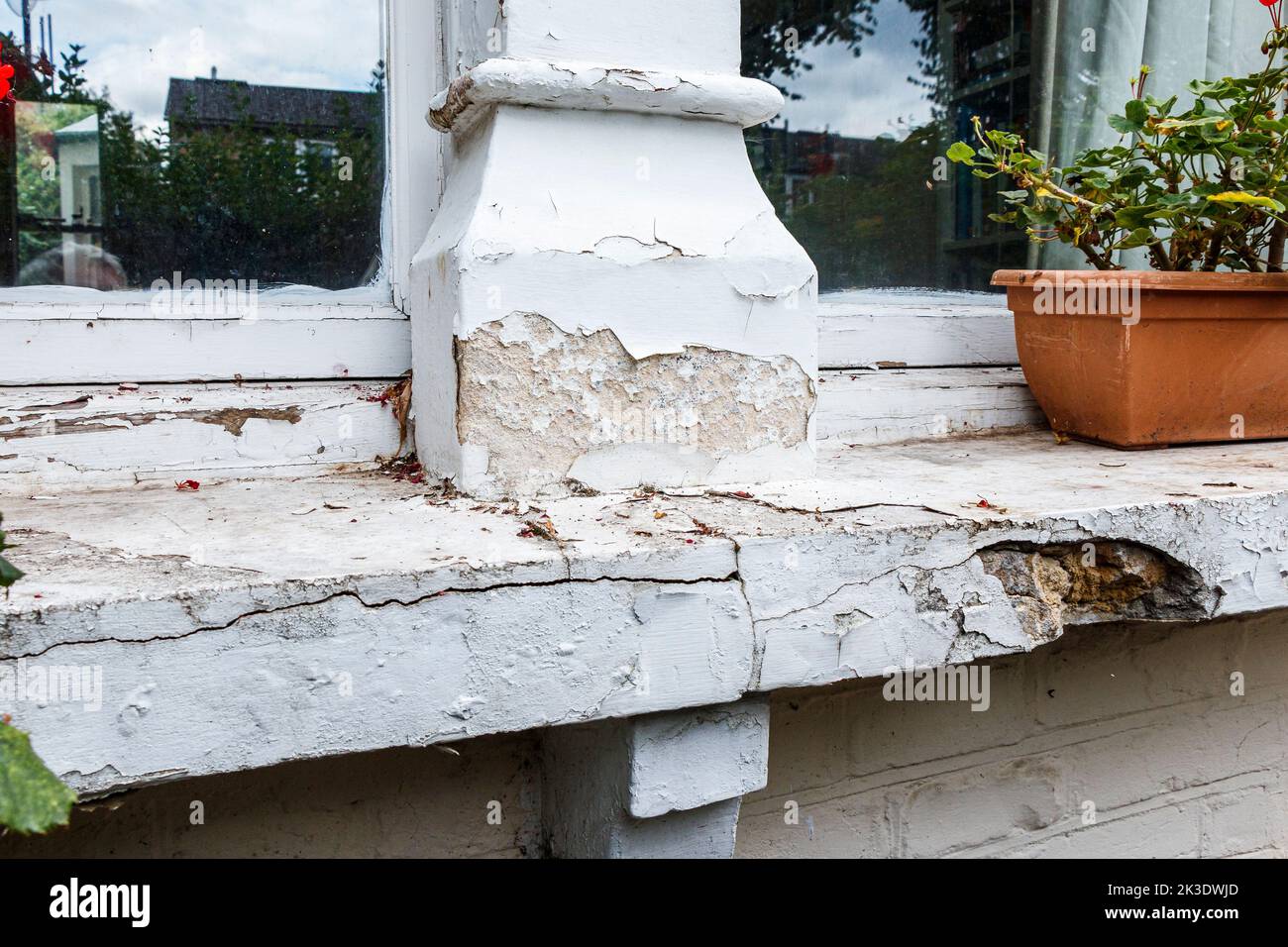 A wooden window frame and windosill in a state of disrepair in a Victorian residential property in London, UK Stock Photo
