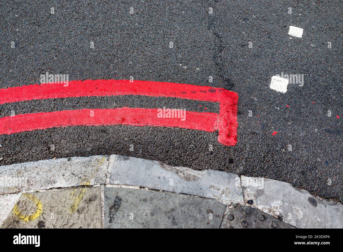 A double red line, signifying a TfL (Transport for London) no-stopping 'red route' in Camden Town, London, UK Stock Photo
